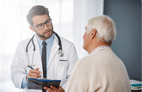 Close up of male doctor with clipboard talking to elderly male patient