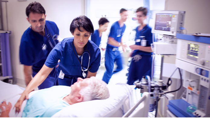 Doctors rushing to help patient in hospital bed
