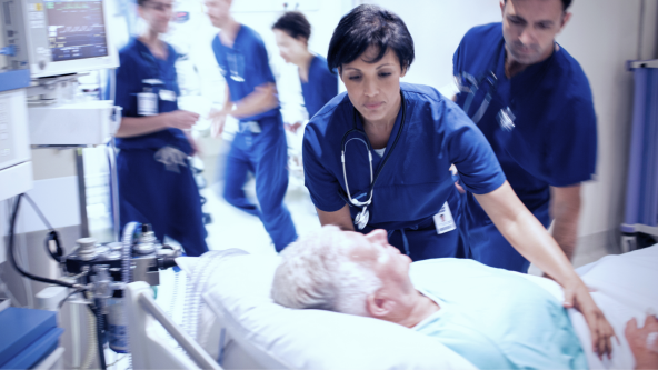 Doctors rushing to help patient in hospital bed