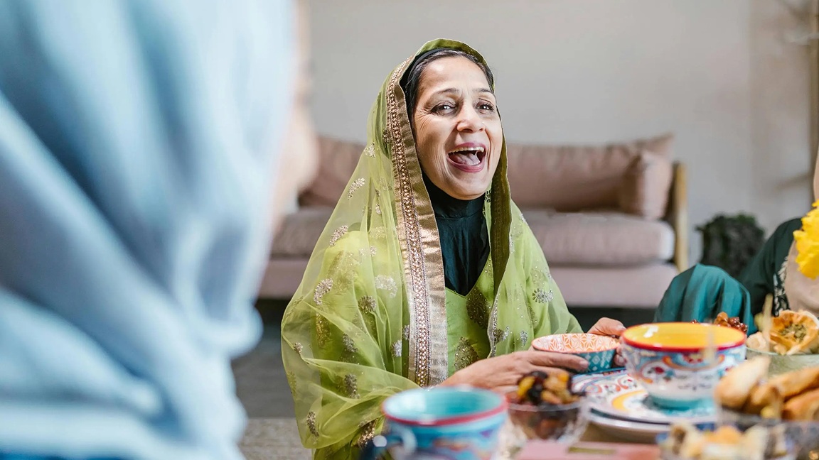 Smiling muslim woman enjoying iftar during ramadan